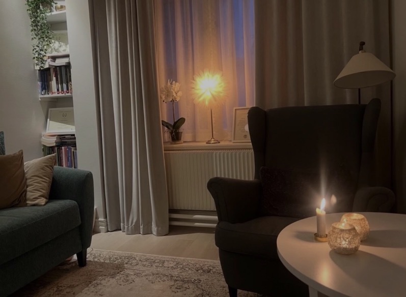Fåtölj och tänt ljus i samtalsrummet på Riddargatan 36
